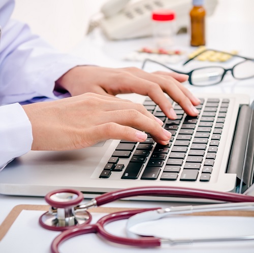 Doctor typing on a computer