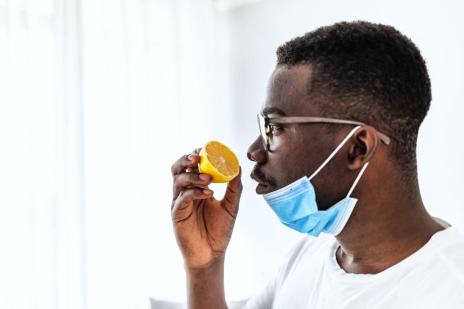 A young COVID-19 male patient is sniffing a lemon for testing a loss of sense of smell.